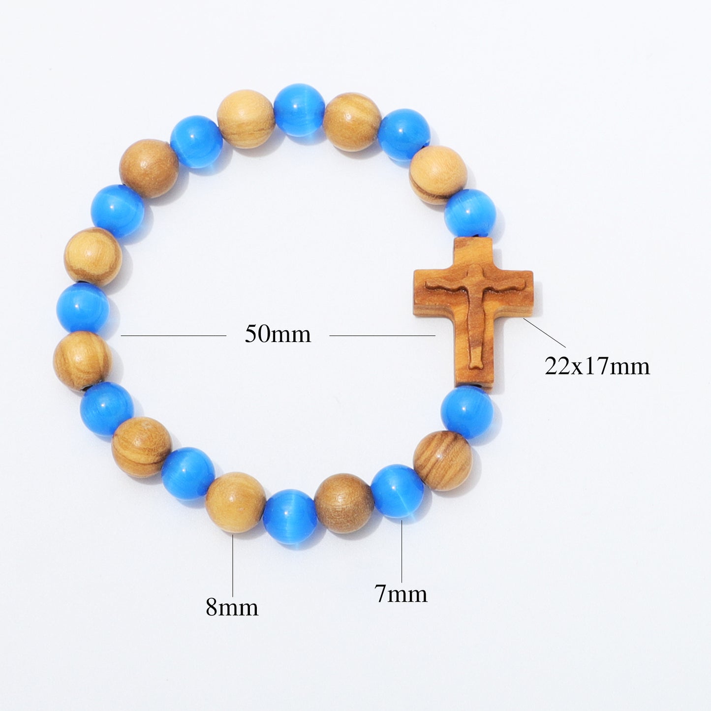 A beaded bracelet with alternating blue and natural wood beads, featuring a wooden crucifix centerpiece. White background with black measurement text and lines indicating dimensions: 50mm for the full bracelet, 22x17mm for the crucifix, 8mm for some beads, and 7mm for others.