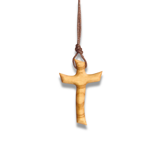 Olive wood cross pendant on a cord against a white background