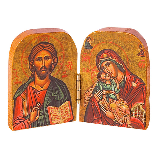 A Byzantine-style diptych religious icon with hinged wooden panels. The left panel depicts Christ with a raised right hand in blessing and an open book in his left, robed in red and green with a halo inscribed with "Ο ΩΝ". The right panel shows the Virgin Mary in a red robe with a blue mantle, holding the child Jesus, both adorned with halos. The background is gold with inscriptions and angelic figures, symbolizing divinity.
