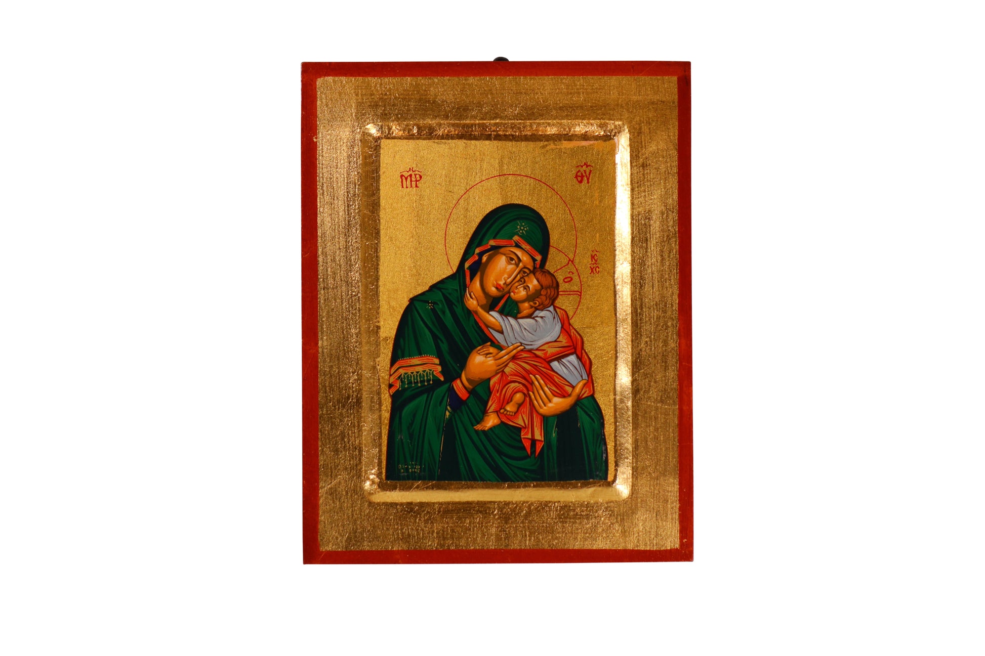 A hand-painted icon of the Virgin Mary in a green robe cradling the infant Jesus against a golden background, within a red frame. Mary has a contemplative expression and a halo inscribed with "MP OY," while Jesus looks outward with a hand raised in blessing and a halo with a cross.