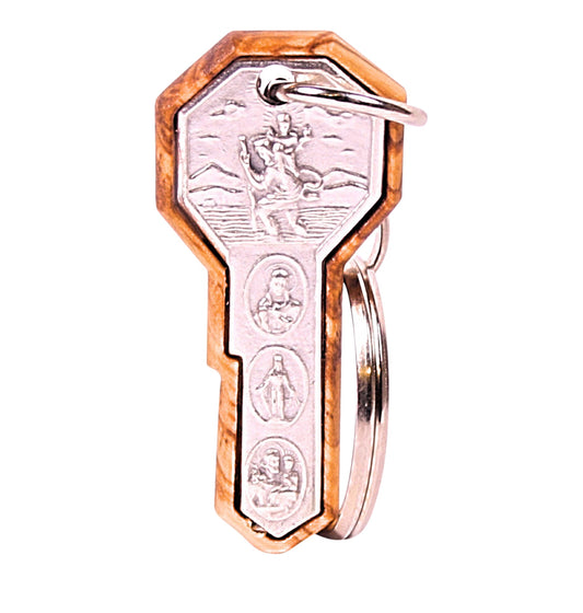 Olive wood pendant keychain featuring a silver-toned metal inset of St. Christopher carrying the Christ child, set within a carved olive wood frame. Below the rectangular frame are three circular religious icons, also in silver tone, depicting various saints. The keychain is completed with a silver-toned ring for keys.