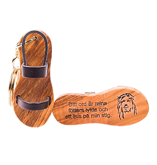 Wooden sandal keychain with leather straps, engraved with Psalm 119:105 in Swedish, symbolizing the pilgrimage of life.