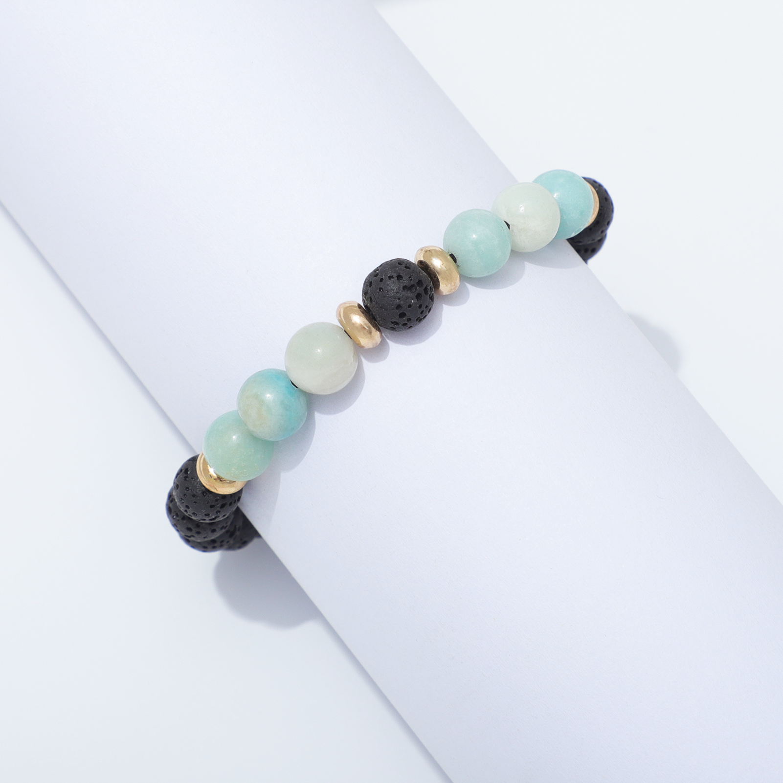 Lava Stone & Moonstone Bracelet Around White Cylinder