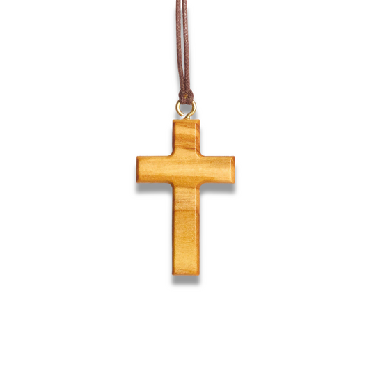 Olive wood cross pendant on a brown cord against a white background