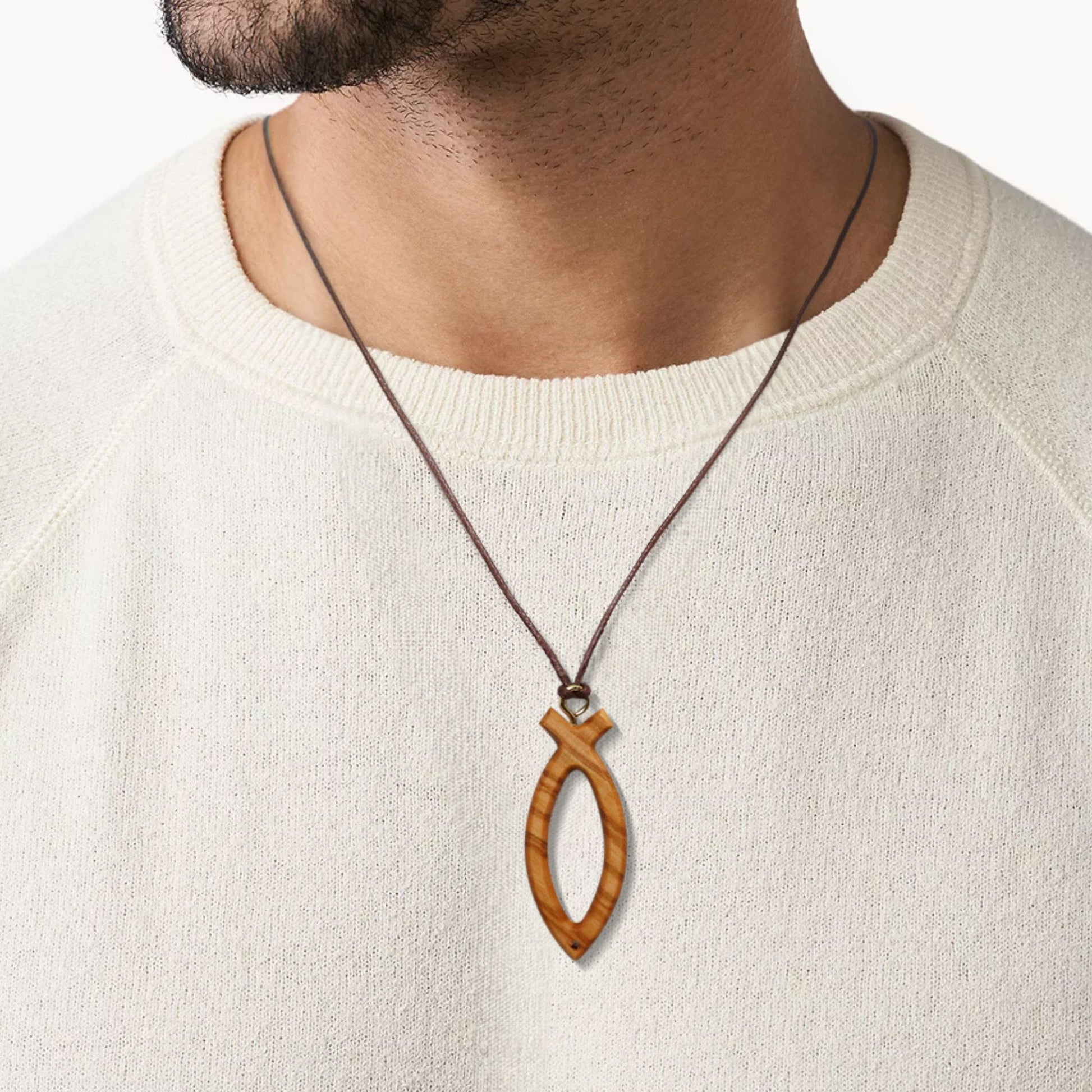 Man wearing an olive wood Ichthus symbol cross necklace