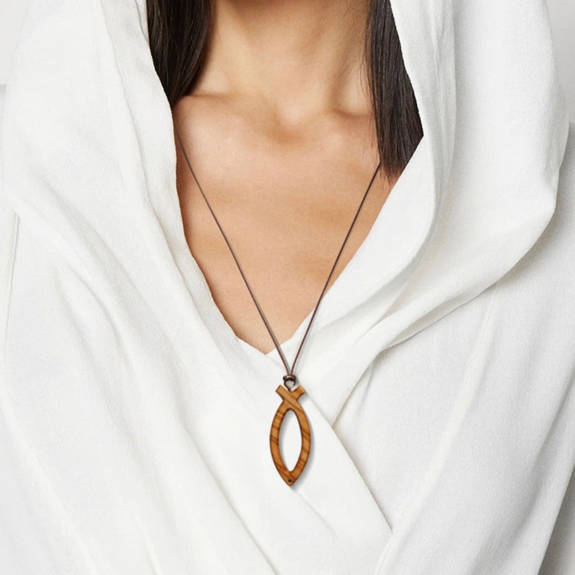 Woman wearing olive wood Ichthus symbol cross necklace