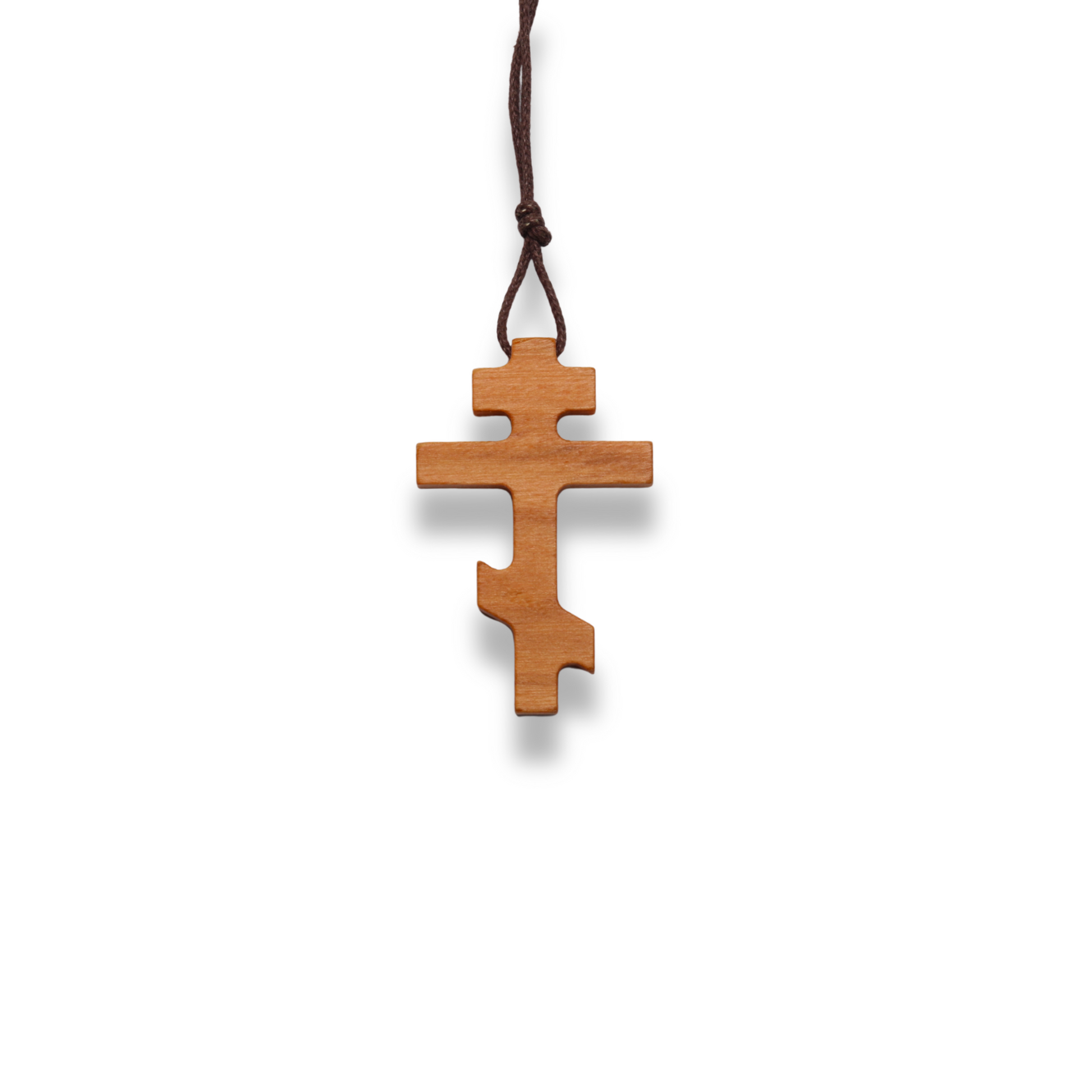 Russian orthodox olive wood cross pendant on a white background
