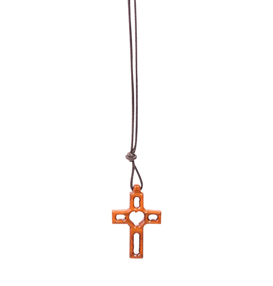 Olive wood cross pendant with a central carved heart and hollowed-out arms and legs, suspended from a soft cotton cord.