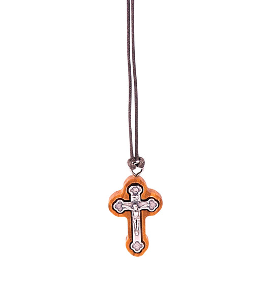 Olive wood crucifix pendant with silver-toned metal depicting Jesus, rounded corners, hanging from a soft cotton cord.