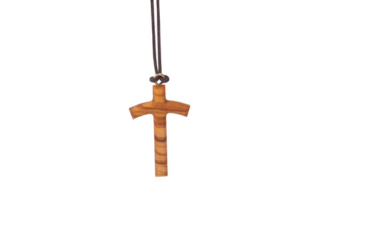 The pendant is a cross made from olive wood, but it's not the typical straight-armed cross you might imagine. Instead, the arms gently curve or bend downward, giving it a distinctive and unique shape.