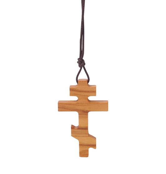 Olive wood Russian Orthodox cross pendant with three horizontal beams, the lowest slanted, hanging from a soft cotton cord.