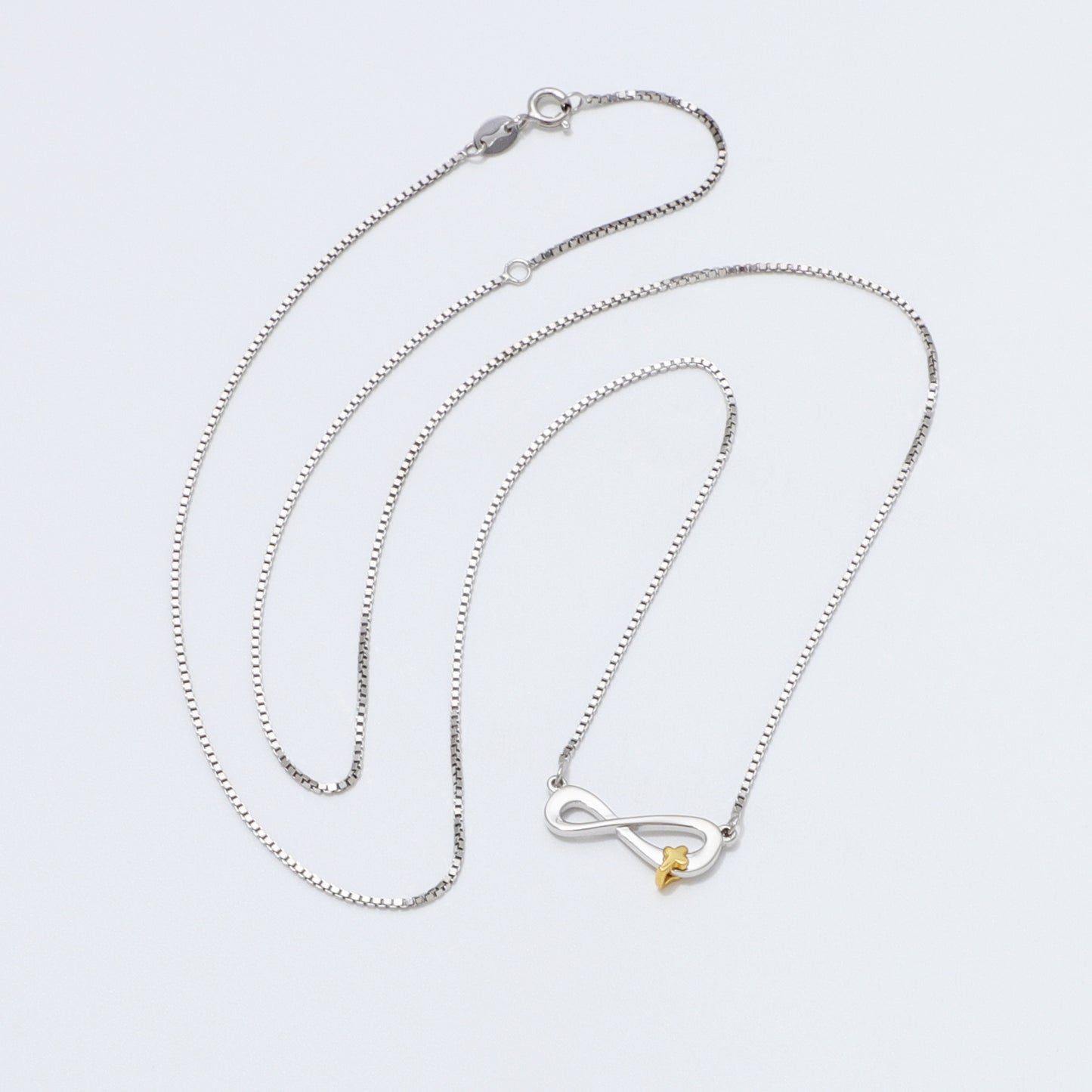 Silver 925 Sterling infinity necklace with a gold cross pendant on a white background
