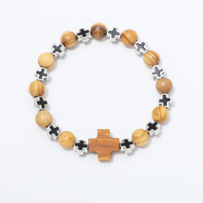 A beaded stretch bracelet featuring light brown wooden beads, silver-toned cross charms, and a larger central wooden cross, displayed on a clean white background.