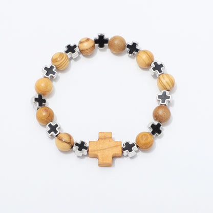 A beaded stretch bracelet featuring natural wood beads, black cross charms, silver cross charms, and a larger wooden cross centerpiece, displayed on a clean white background.