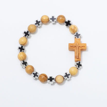 A wooden and metal beaded bracelet featuring light brown wood beads, black cross inlays, and a carved wooden crucifix, displayed on a clean white background.