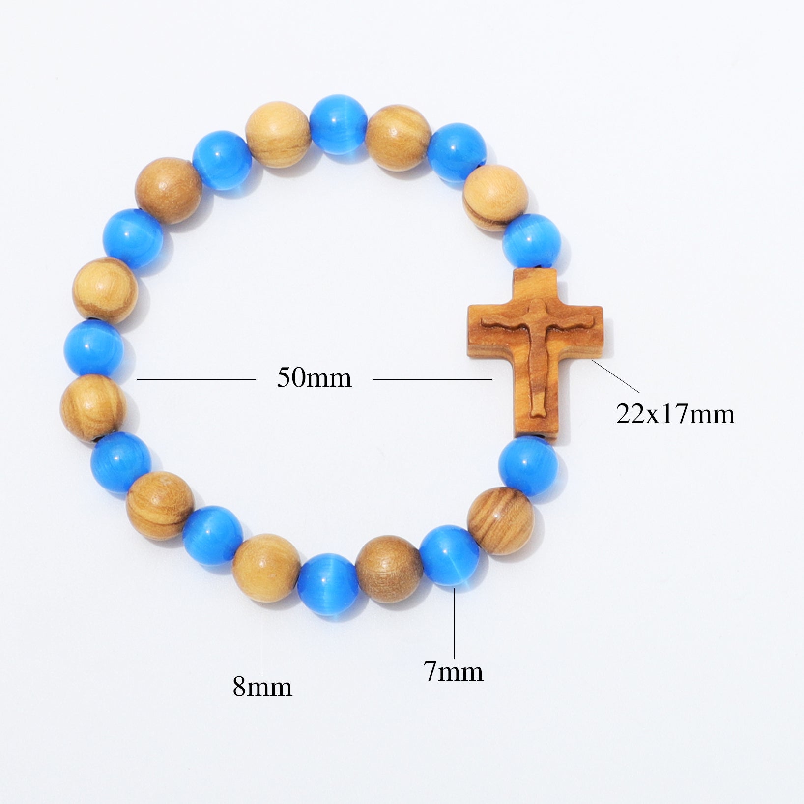 A beaded bracelet with alternating blue and natural wood beads, featuring a wooden crucifix centerpiece. White background with black measurement text and lines indicating dimensions: 50mm for the full bracelet, 22x17mm for the crucifix, 8mm for some beads, and 7mm for others.