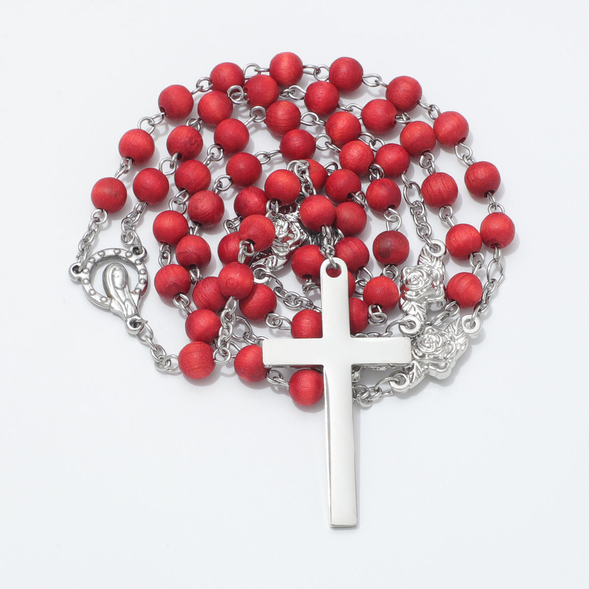A rosary necklace featuring matte red wooden beads on a silver-tone metal chain, complete with a polished silver cross.