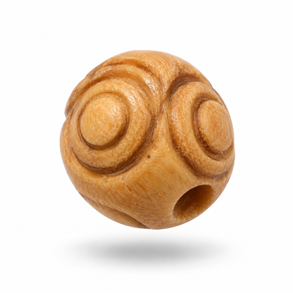 A single round wooden bead with carved spiral patterns and a central hole, shown floating against a white background with a soft shadow underneath.