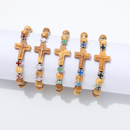 Five wooden cross bracelets with colorful enamel details are displayed on a white cylindrical stand against a white background.