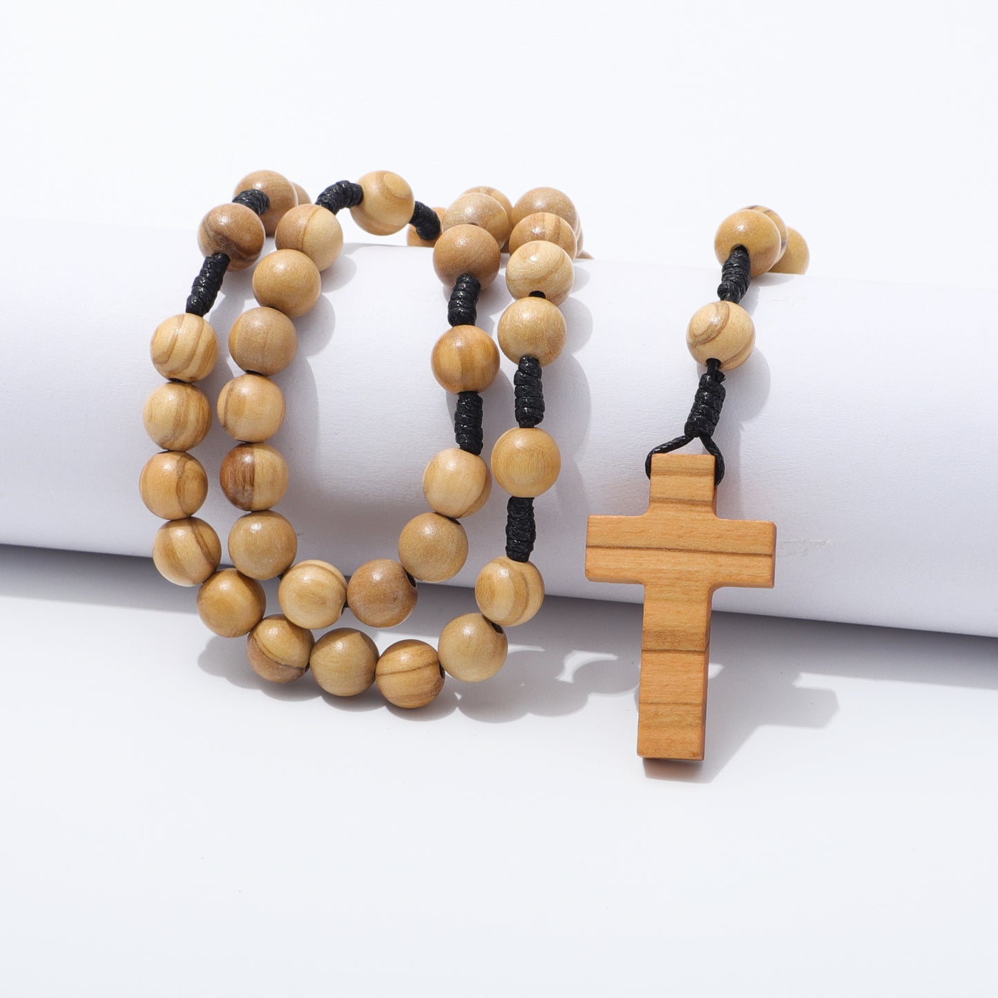 Olive wood rosary with a cross pendant on a white background