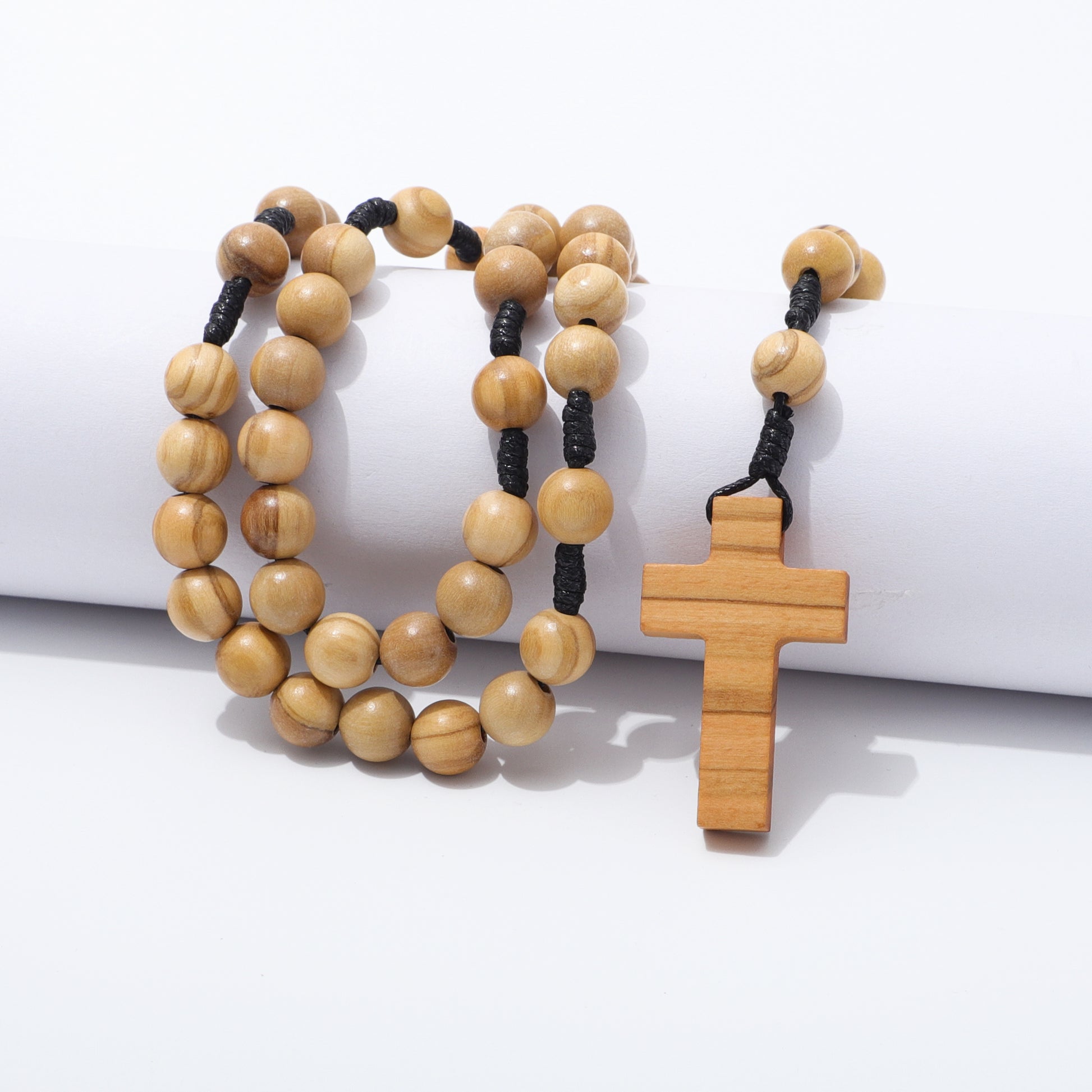 Olive wood rosary with a cross pendant on a white background
