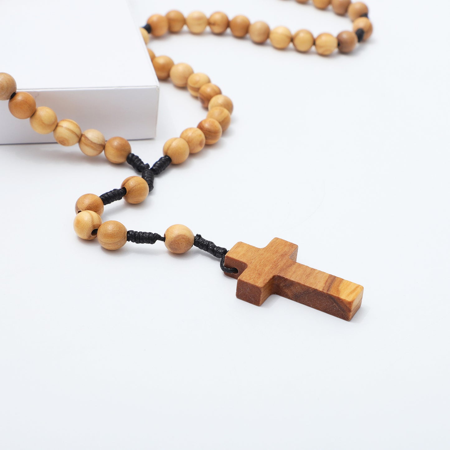 Wooden rosary with a cross on a white background