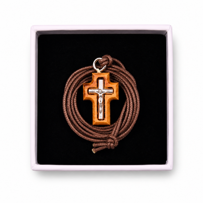 Cross pendant with brown cord in a black box