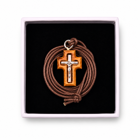 Cross pendant with brown cord in a black box