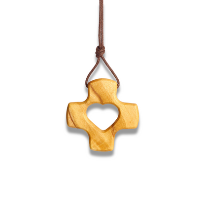 Wooden cross pendant with heart cutout on a white background