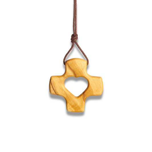Wooden cross pendant with heart cutout on a white background