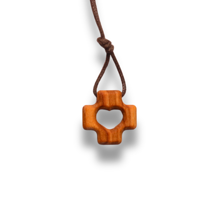 Olive wood cross pendant with heart cutout on a white background