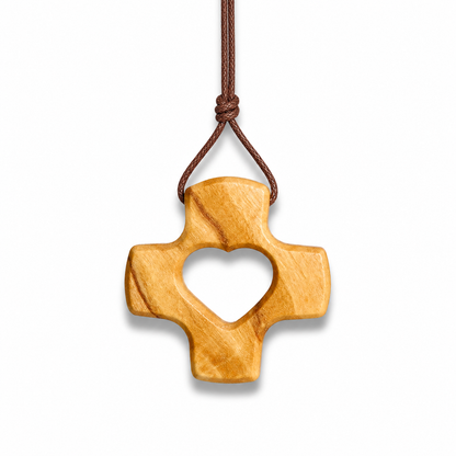 Wooden cross pendant with heart cutout on a white background