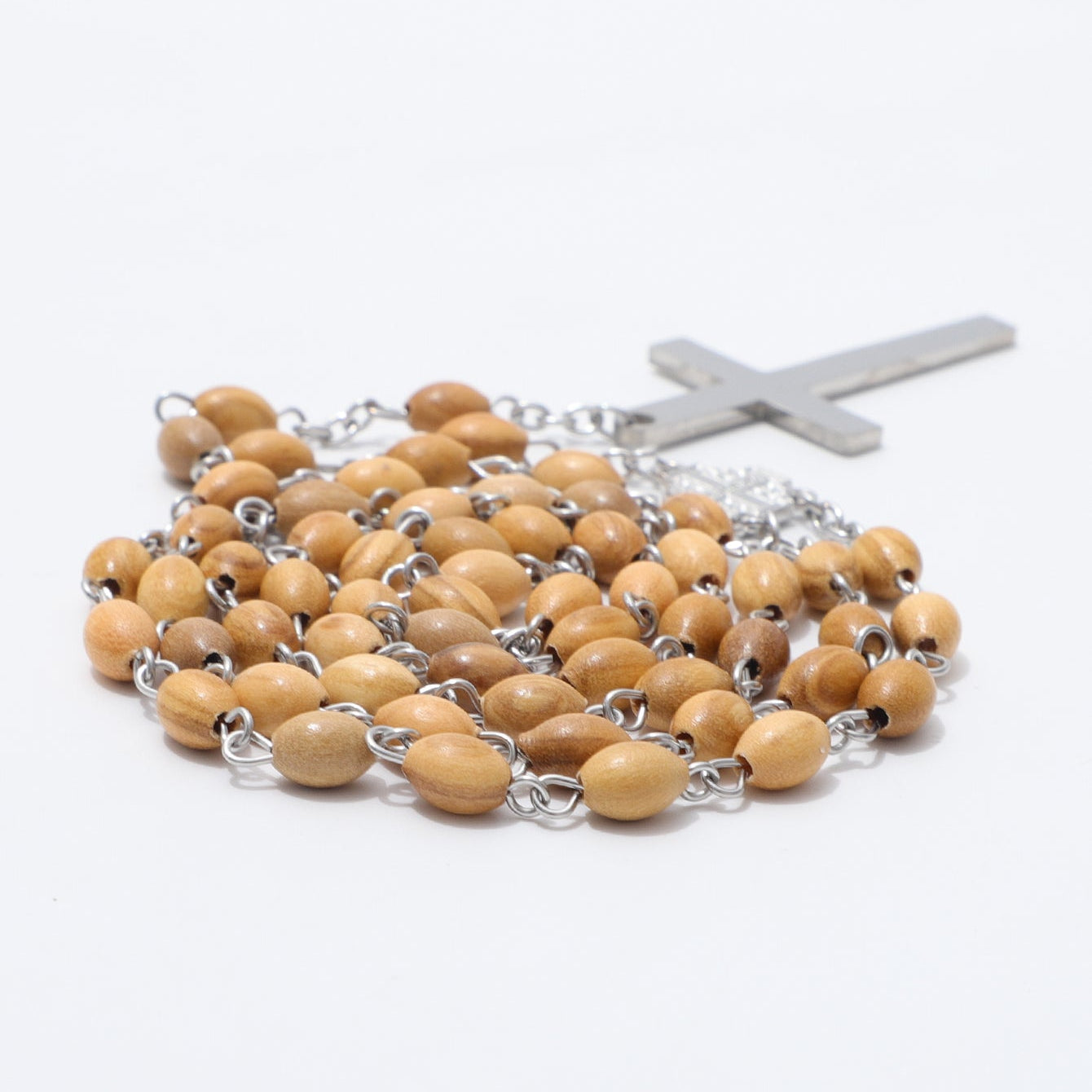 A wooden bead rosary with light tan oval beads connected by silver-tone chains and a matching silver-tone cross, photographed on a plain white background.