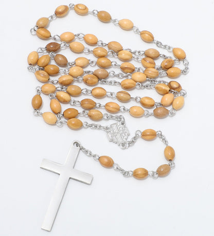 A wooden bead rosary necklace with light brown oval beads, silver chain links, and a polished silver cross pendant, displayed on a clean white background.