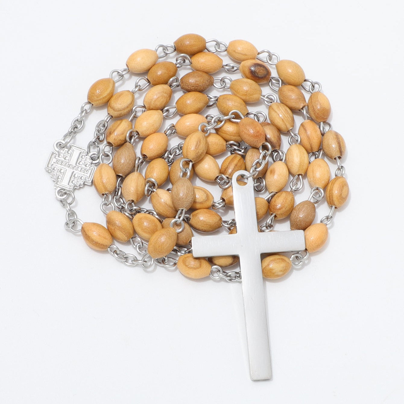 A wooden bead rosary with light brown oval beads, silver-tone chain links, a silver crucifix, and a small silver centerpiece, displayed on a clean white background.