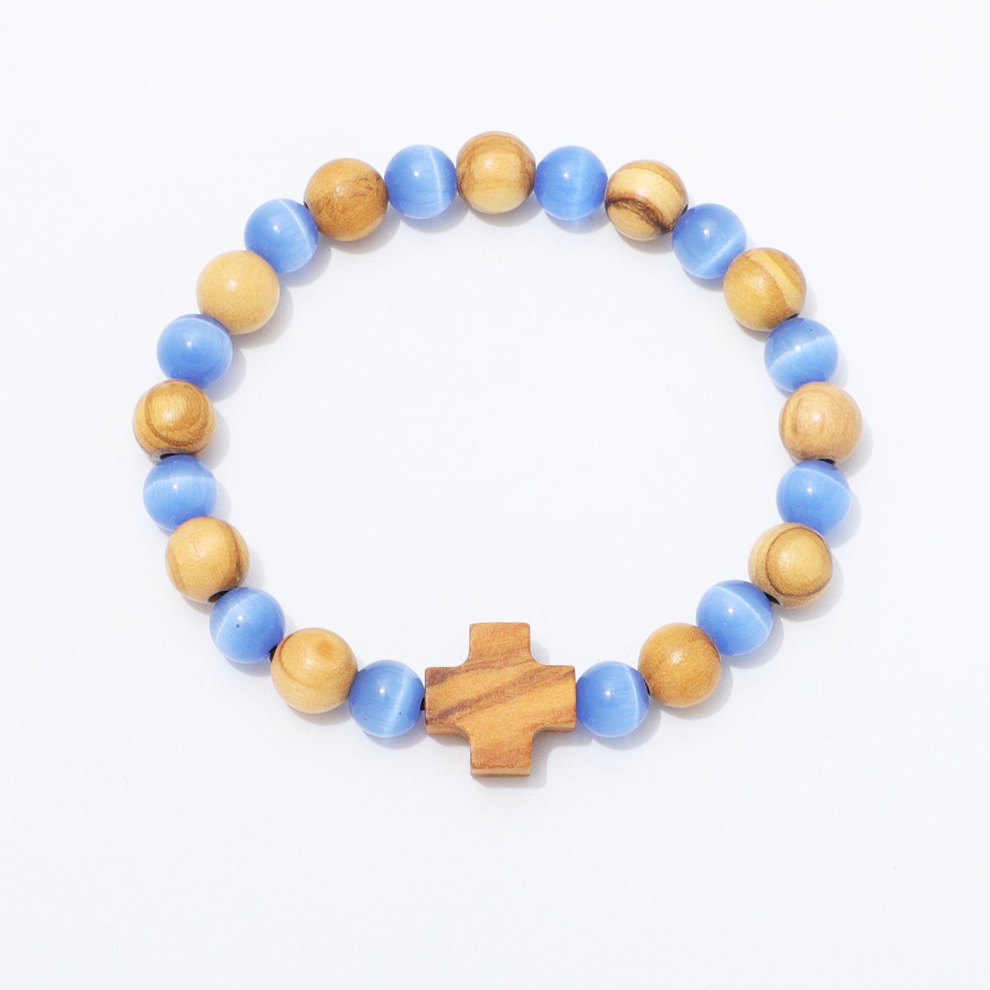A beaded stretch bracelet featuring alternating light blue and natural wood beads, with a small wooden cross charm at the front, displayed on a clean white background.