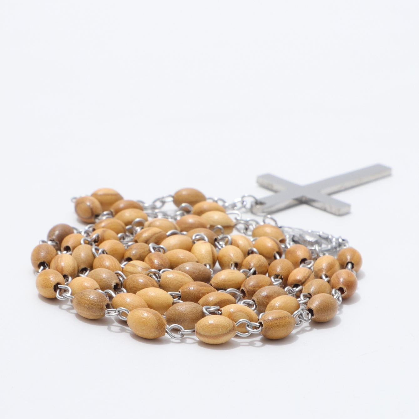 A wooden rosary with light brown oval beads and a silver-tone metal cross, photographed on a clean white background.