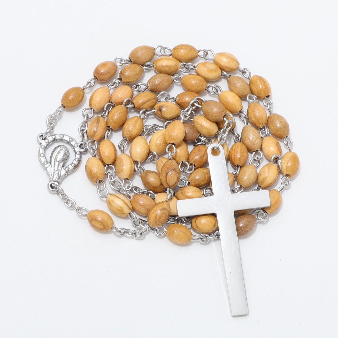 A rosary necklace featuring light brown wooden beads on a silver-tone chain, with a polished silver cross pendant and a decorative silver clasp, displayed on a clean white background.
