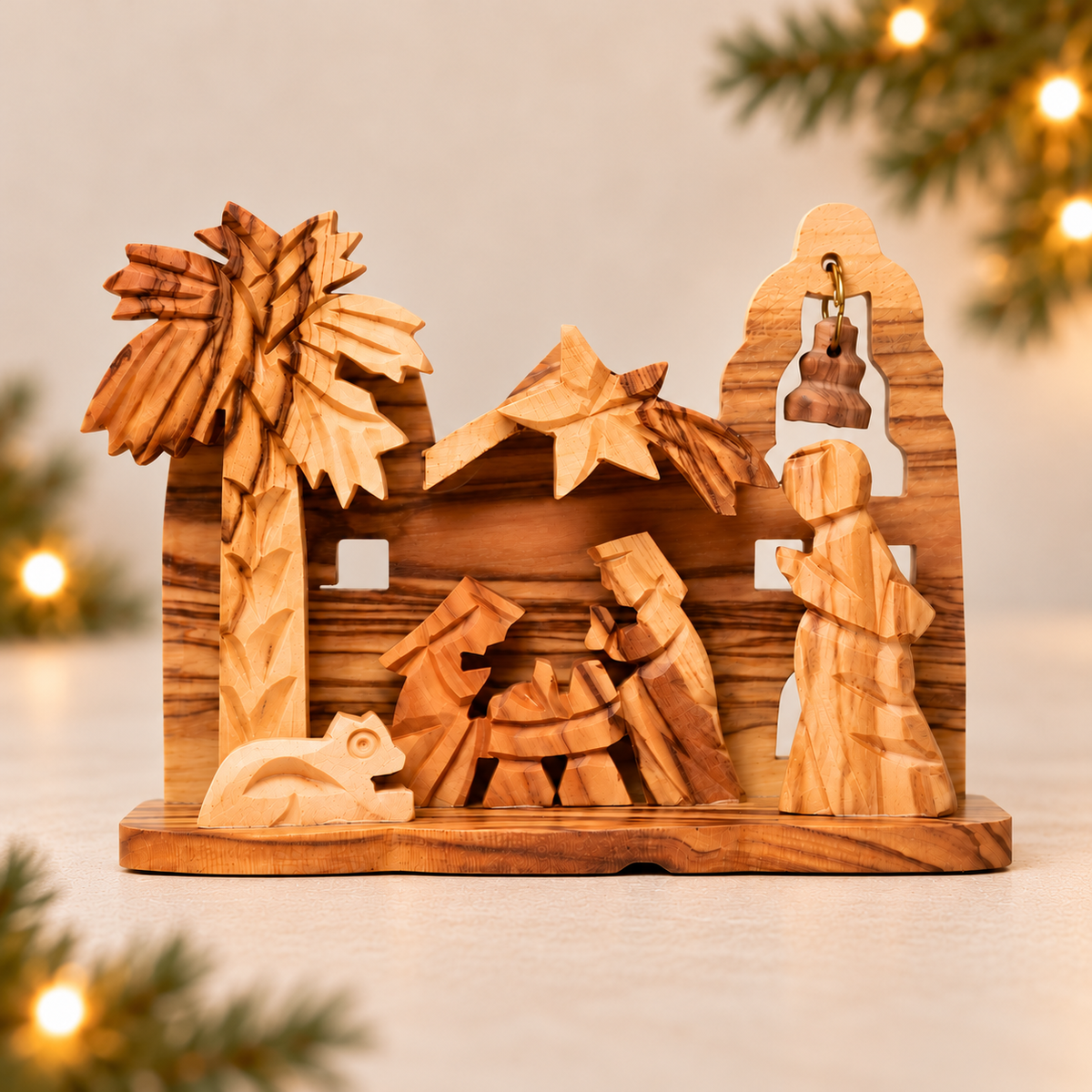 Hand-carved olive wood nativity scene figurine on a light wooden base, featuring Mary, Joseph, baby Jesus in a manger, a palm tree, and a star, photographed on a light surface with a softly blurred holiday background.