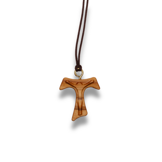Olive wood cross pendant on a brown cord against a white background