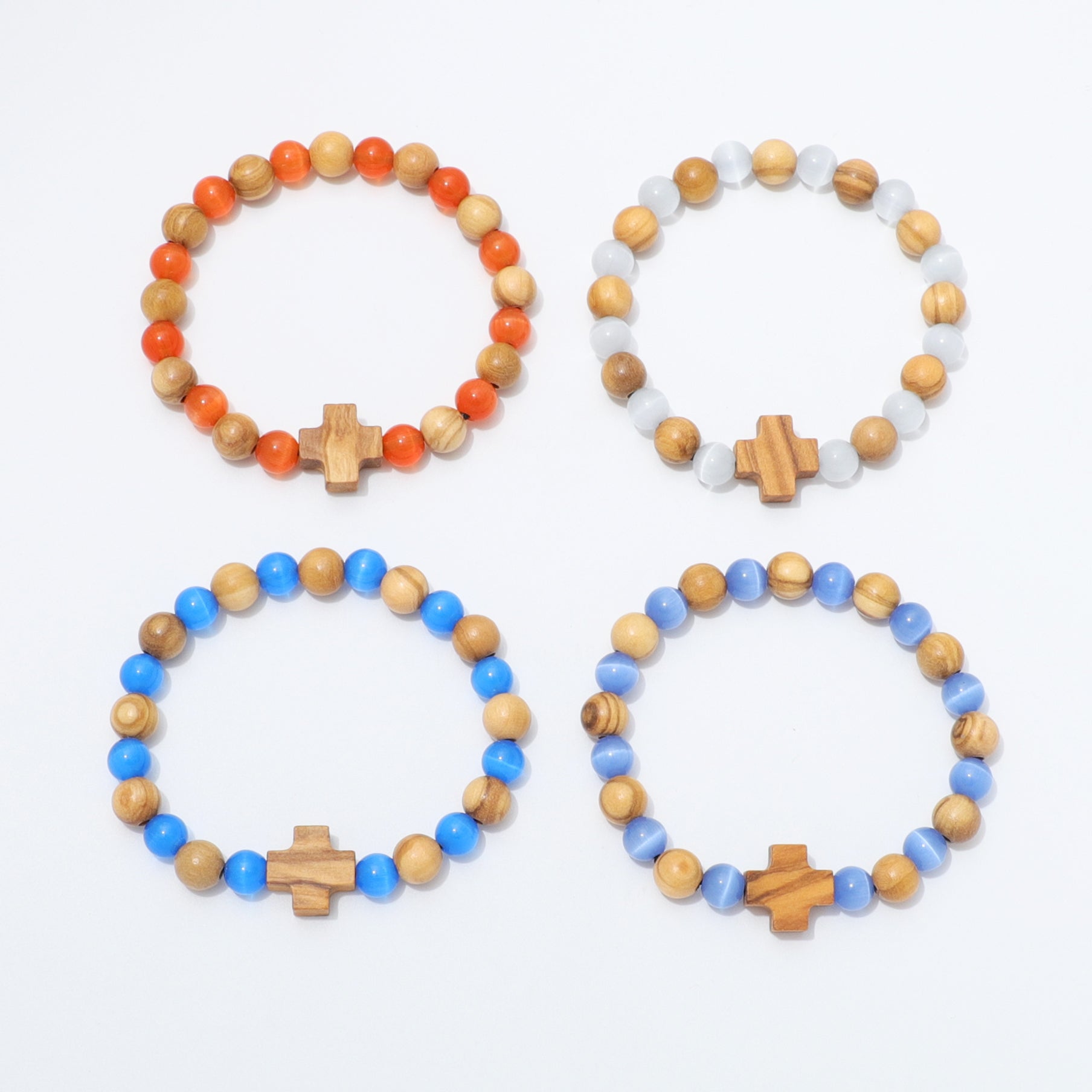 Four beaded stretch bracelets arranged in a 2x2 grid on a white background. Each bracelet features natural wood beads, smooth blue beads, and a central wooden cross charm.