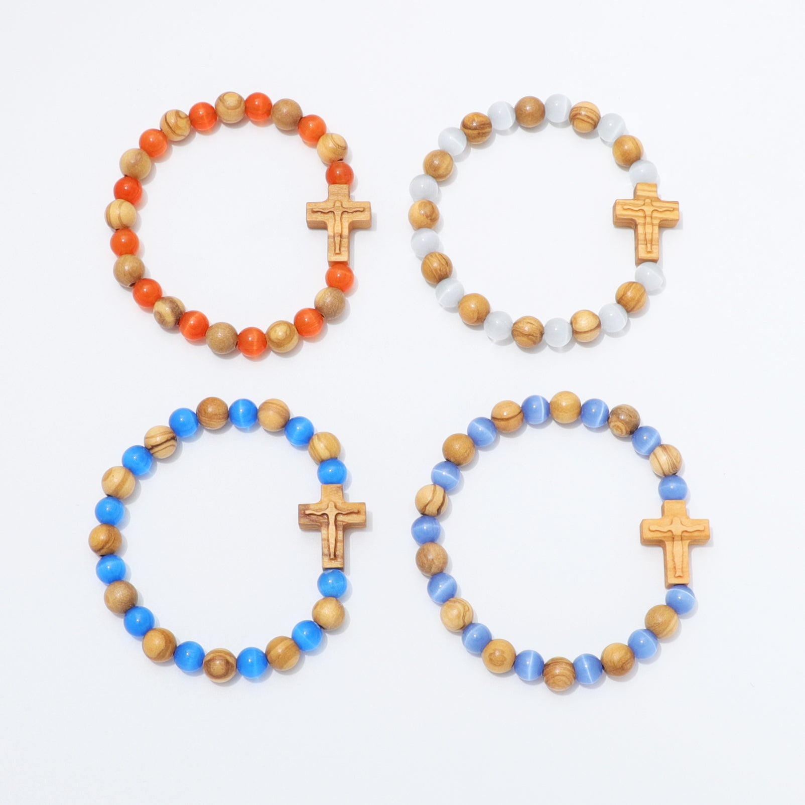 Four beaded bracelets arranged in a 2x2 grid on a white background. Each bracelet features wooden beads, translucent white beads, and a small wooden cross charm.