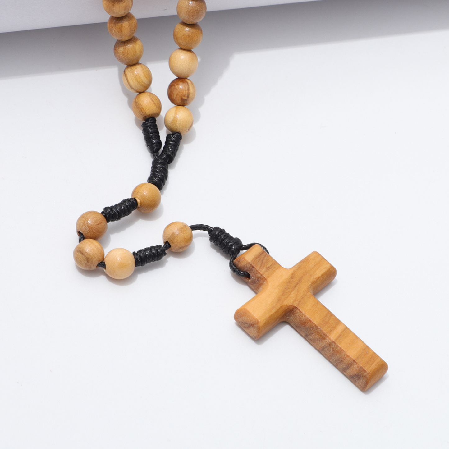 Wooden rosary with a cross on a white background