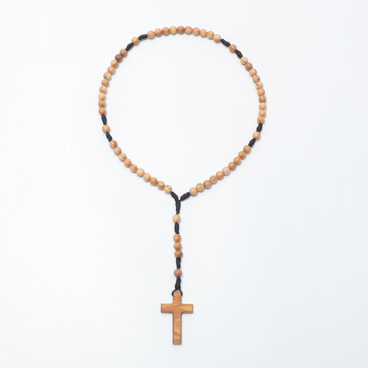 Full view of the olive wood pocket rosary with small round beads, black knotted cord and a plain wooden cross