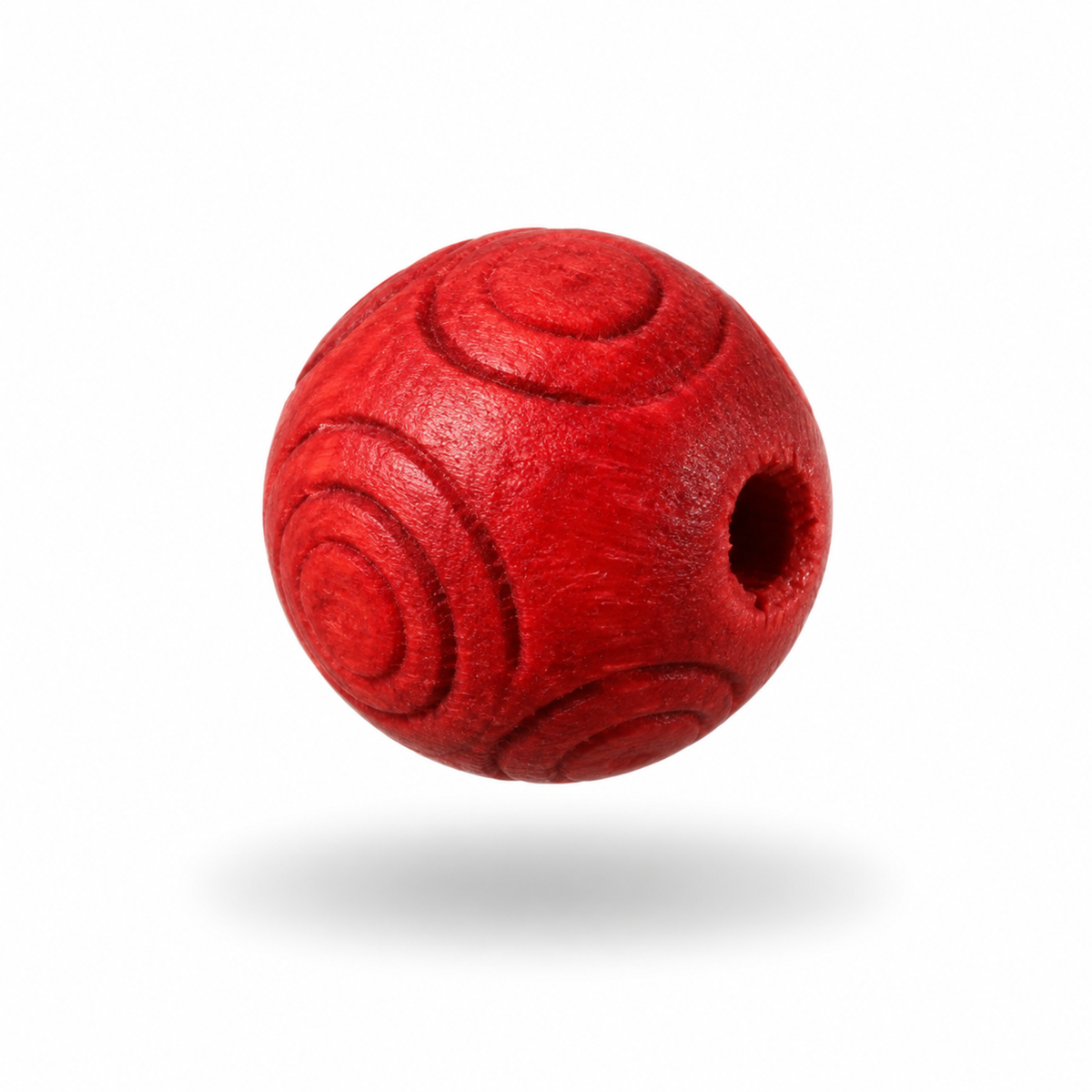 A single round red wooden bead with carved spiral patterns and a central hole, floating against a white background with a soft shadow underneath.