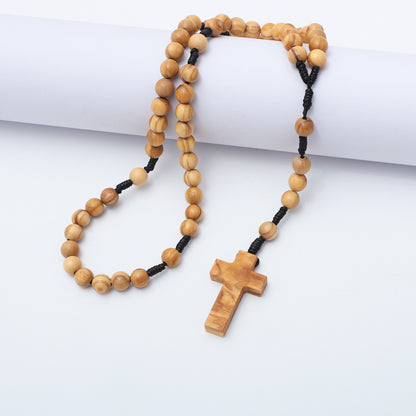 Olive wood rosary with smaller round beads draped over a white block