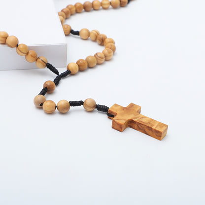 Close view of the olive wood cross and beads on knotted cord