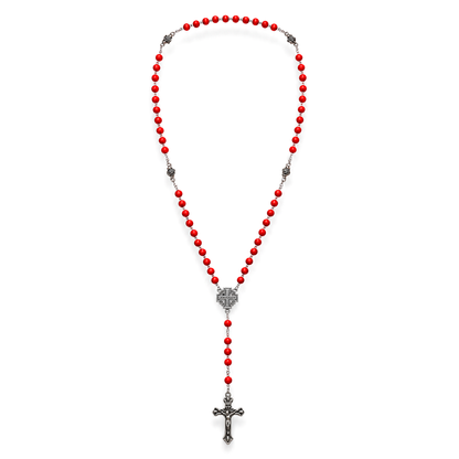 A red beaded rosary necklace with silver-toned metal accents, including a central heart-shaped medallion and a dangling crucifix, shown on a plain white background.