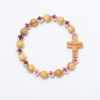 A beaded bracelet featuring light brown wooden beads, silver-toned cross-shaped beads with red cross inlays, and a wooden crucifix, displayed on a clean white background.