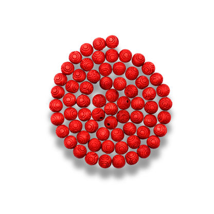 Red rose-shaped beads arranged in a circular pattern on a white background